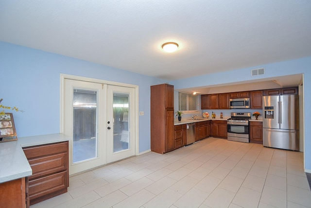 kitchen featuring stainless steel appliances, french doors, and sink