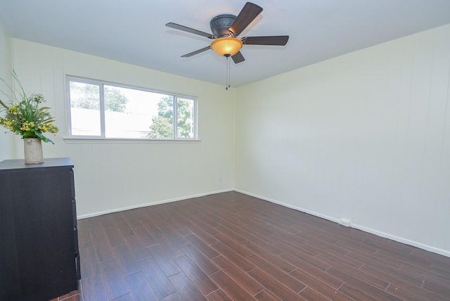 empty room with ceiling fan and dark hardwood / wood-style floors