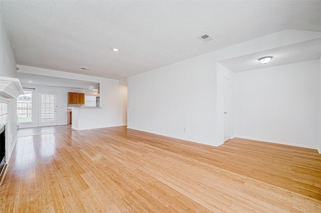 unfurnished living room featuring a textured ceiling and light wood-type flooring