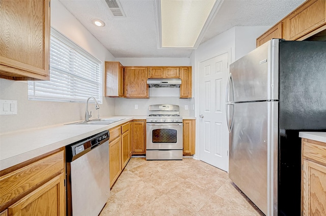 kitchen featuring sink, a textured ceiling, and stainless steel appliances