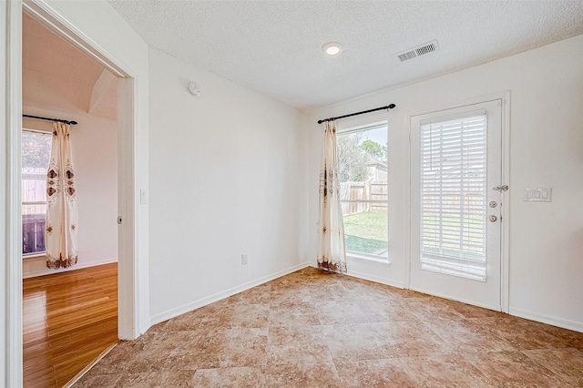 unfurnished room with a textured ceiling