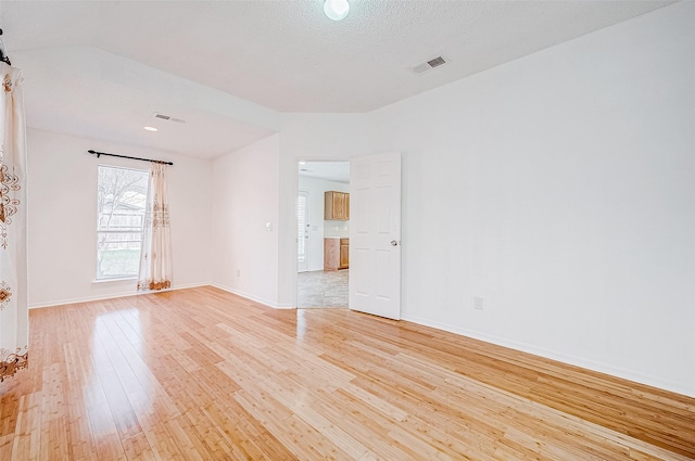 empty room featuring a textured ceiling and light wood-type flooring