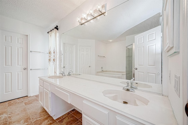 bathroom featuring a textured ceiling, shower with separate bathtub, and vanity