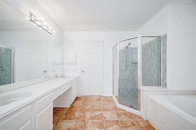 bathroom with separate shower and tub, vanity, and a textured ceiling