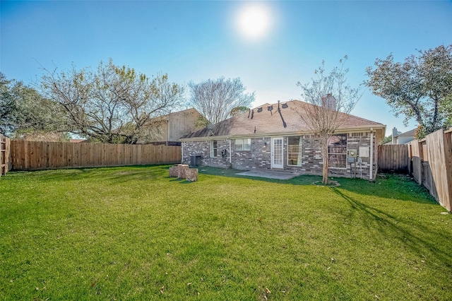 rear view of house with a lawn and a patio