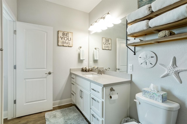 bathroom featuring toilet, wood-type flooring, and vanity