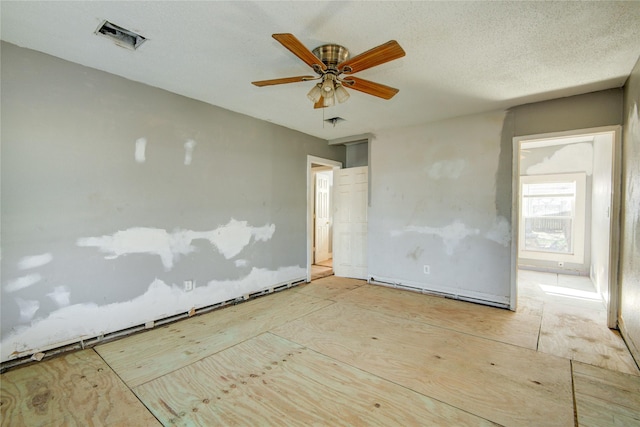 empty room featuring a textured ceiling and ceiling fan