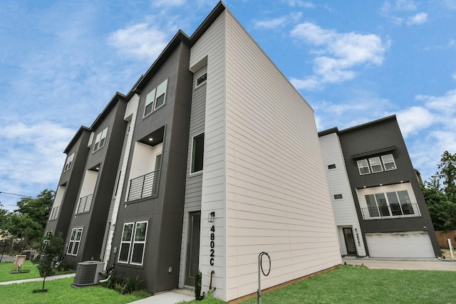 view of building exterior featuring central air condition unit and a garage