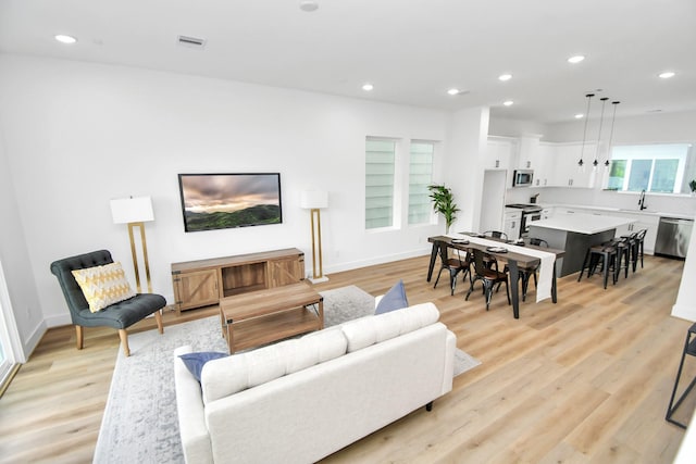 living room featuring light wood-type flooring and sink