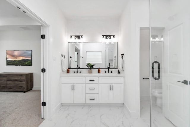 bathroom with toilet, vanity, and walk in shower