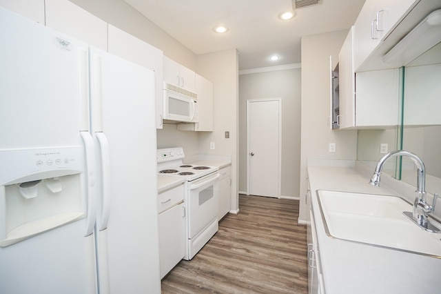 kitchen featuring sink, white appliances, and white cabinetry