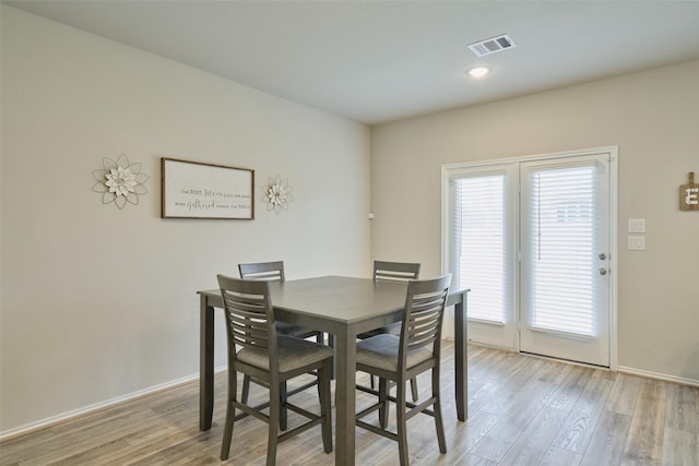 dining area featuring light wood-type flooring and a healthy amount of sunlight