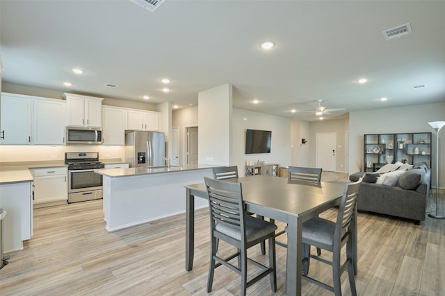 dining space featuring sink, ceiling fan, and light hardwood / wood-style floors