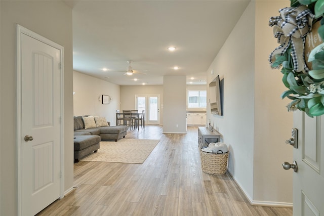 living room with light wood-type flooring and ceiling fan