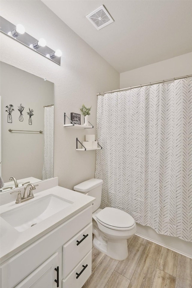 bathroom with toilet, wood-type flooring, vanity, and a shower with shower curtain