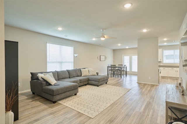 living room with light wood-type flooring and ceiling fan