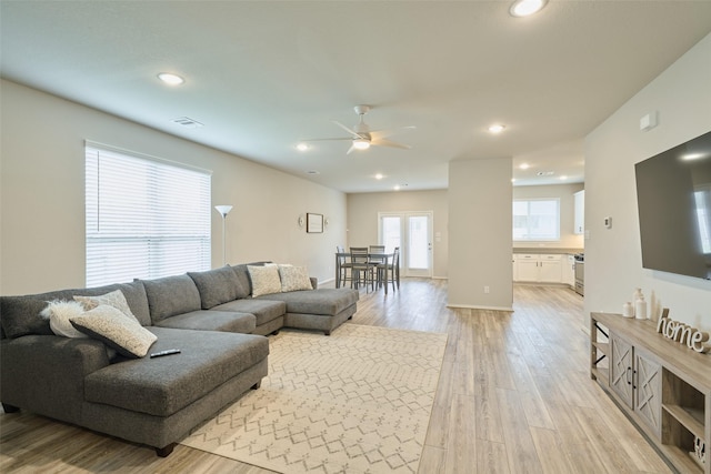 living room featuring ceiling fan and light wood-type flooring