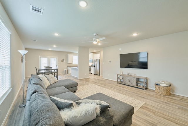 living room featuring ceiling fan and light hardwood / wood-style floors