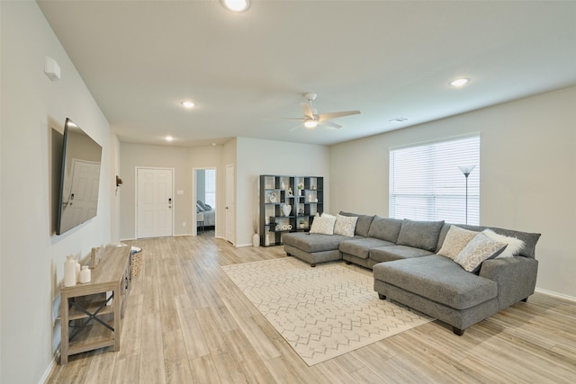 living room featuring ceiling fan and light wood-type flooring