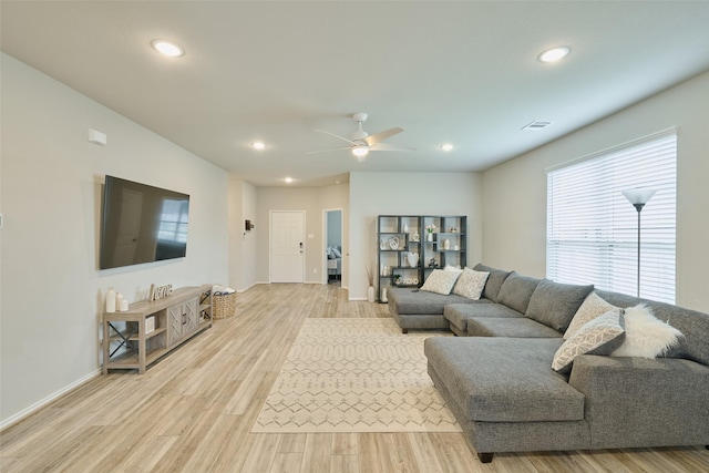 living room with ceiling fan and light hardwood / wood-style flooring