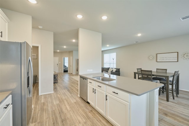 kitchen with sink, white cabinetry, light hardwood / wood-style floors, and appliances with stainless steel finishes