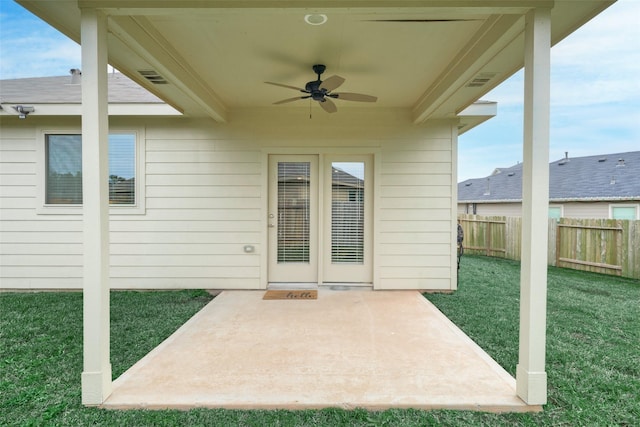 entrance to property featuring ceiling fan, a yard, and a patio area