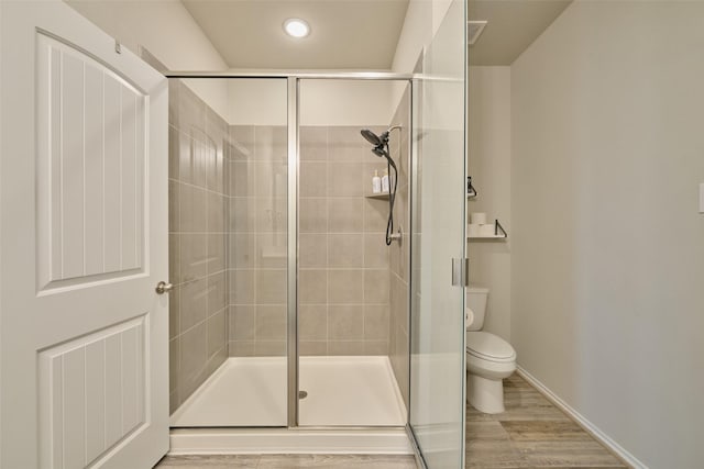 bathroom with toilet and an enclosed shower