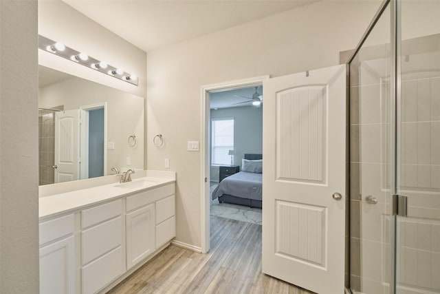 bathroom featuring ceiling fan, walk in shower, hardwood / wood-style floors, and vanity