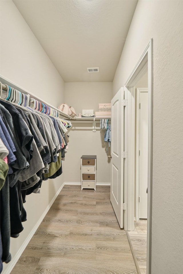 spacious closet with light hardwood / wood-style flooring