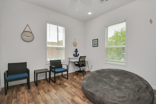 living area with ceiling fan and dark hardwood / wood-style floors