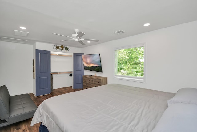 bedroom with ceiling fan, dark wood-type flooring, and a closet