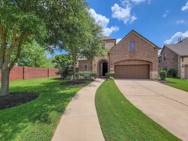 view of front of house featuring brick siding, a front lawn, fence, concrete driveway, and stone siding