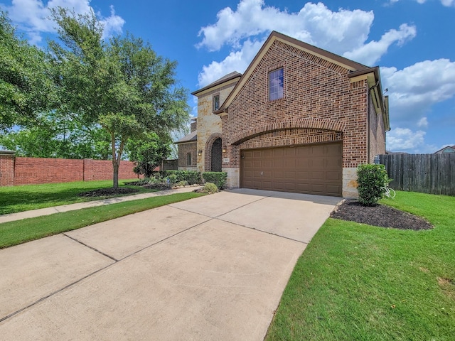 traditional home featuring driveway, brick siding, a front lawn, an attached garage, and stone siding
