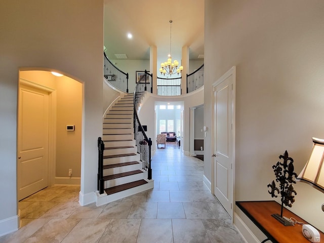 foyer with an inviting chandelier, baseboards, a high ceiling, and stairway