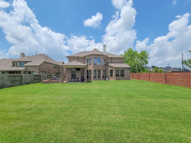 back of property featuring a gazebo and a yard