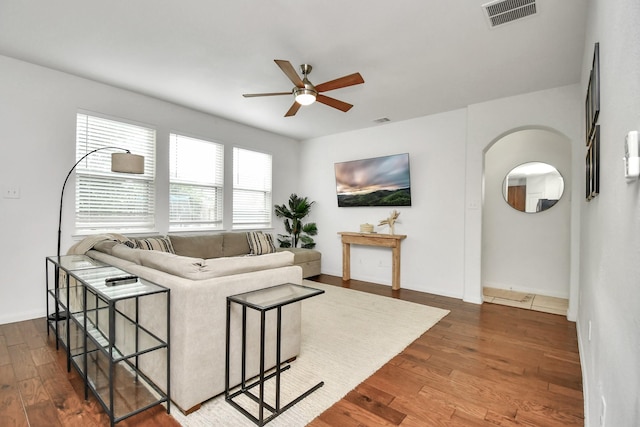 living room with dark hardwood / wood-style flooring and ceiling fan