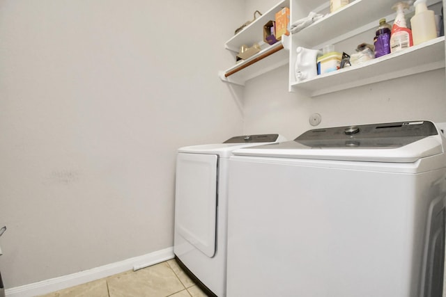 washroom featuring washing machine and dryer and light tile patterned floors