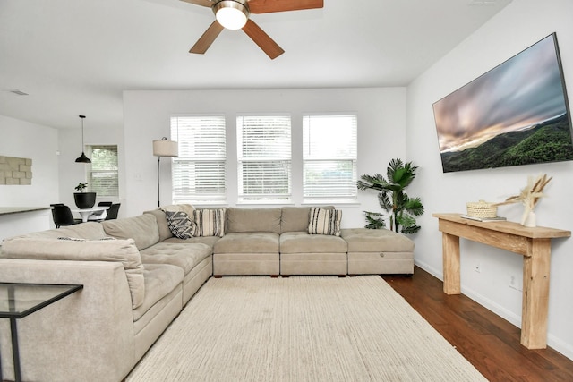 living room with ceiling fan, dark wood-type flooring, and a wealth of natural light