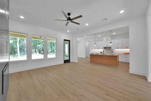 interior space featuring sink, ceiling fan, and light hardwood / wood-style flooring