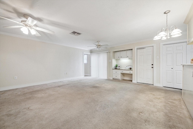 unfurnished living room featuring ceiling fan with notable chandelier, light carpet, and crown molding