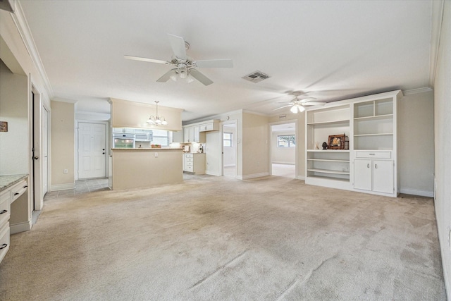 unfurnished living room featuring ceiling fan with notable chandelier, crown molding, and light colored carpet