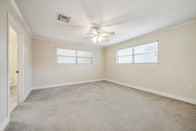 unfurnished room with ceiling fan, light colored carpet, and crown molding