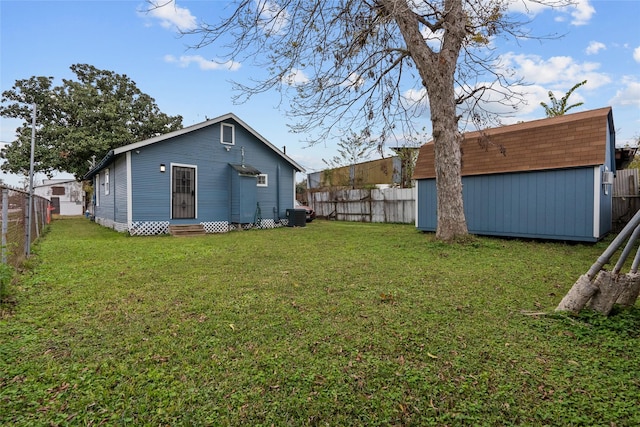 view of yard featuring a storage unit and central AC