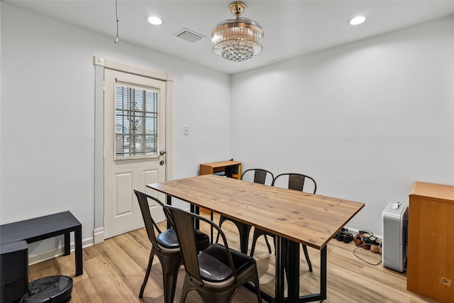 dining area featuring light hardwood / wood-style floors and a chandelier