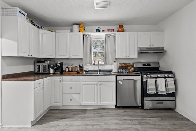 kitchen featuring sink, white cabinetry, light hardwood / wood-style floors, and appliances with stainless steel finishes