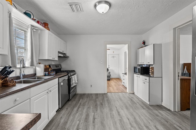 kitchen featuring stainless steel appliances, light wood-type flooring, white cabinetry, and sink