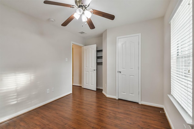 unfurnished bedroom featuring ceiling fan and dark wood-type flooring