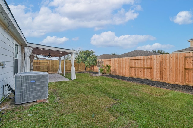 view of yard featuring a patio, central air condition unit, and ceiling fan