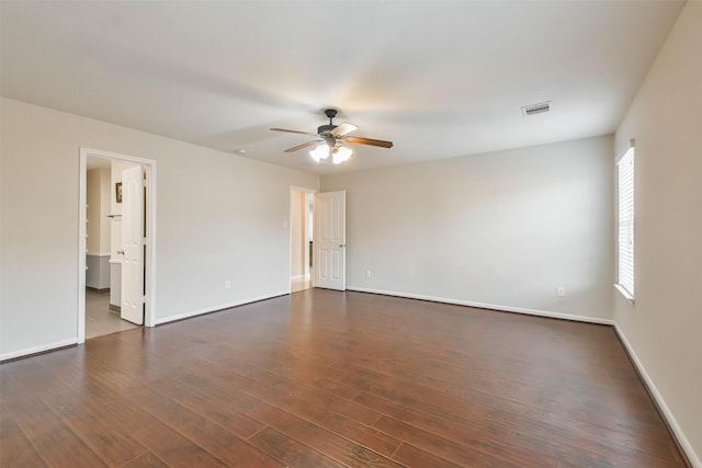 spare room with dark hardwood / wood-style flooring and ceiling fan