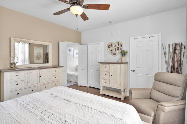 bedroom with ensuite bath, ceiling fan, and dark hardwood / wood-style flooring